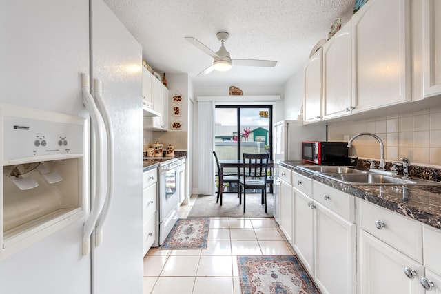 kitchen featuring sink, light tile patterned floors, white cabinets, and white appliances