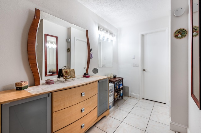 bathroom featuring tile patterned floors, vanity, and a textured ceiling