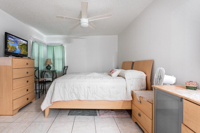 tiled bedroom with ceiling fan and a textured ceiling