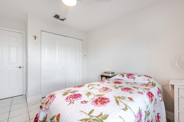 tiled bedroom with ceiling fan and a closet