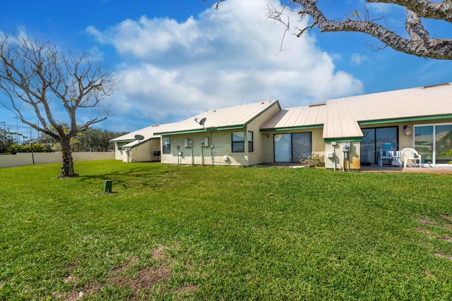 rear view of property featuring a yard and a patio area