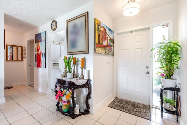 entrance foyer with light tile patterned floors and a textured ceiling