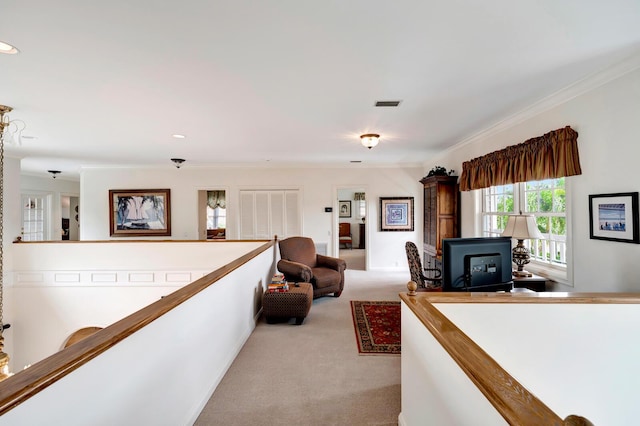 hallway featuring light carpet, crown molding, and a wood stove