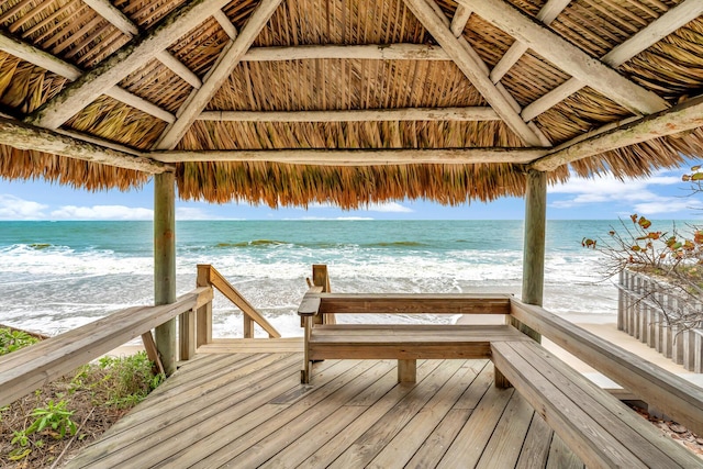 view of dock featuring a gazebo, a water view, and a view of the beach