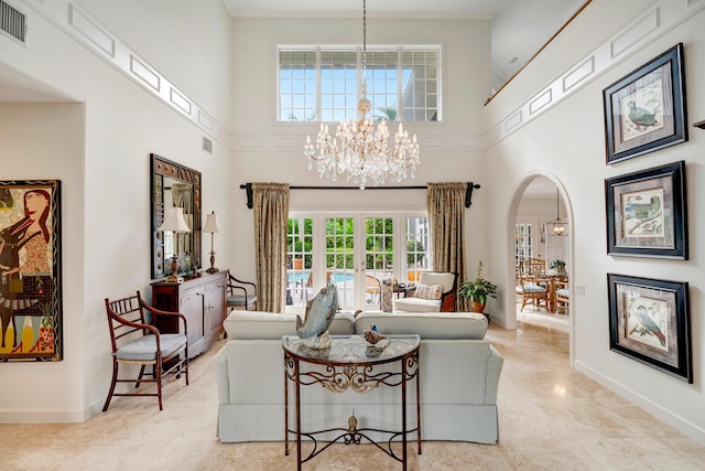 living room with french doors, a chandelier, and a high ceiling