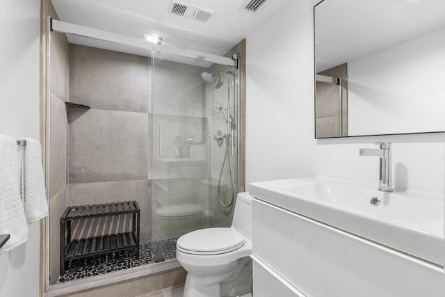 bathroom with vanity, toilet, a shower with door, and heating unit