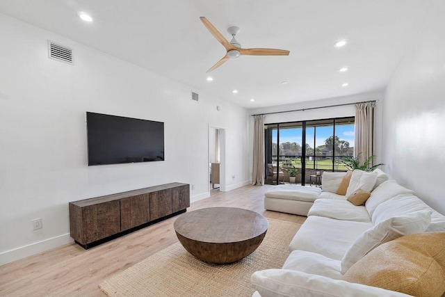 living room with ceiling fan and light hardwood / wood-style flooring