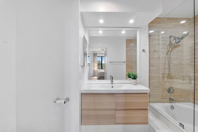 bathroom featuring tiled shower / bath combo and vanity