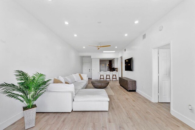 living room featuring ceiling fan and light hardwood / wood-style flooring