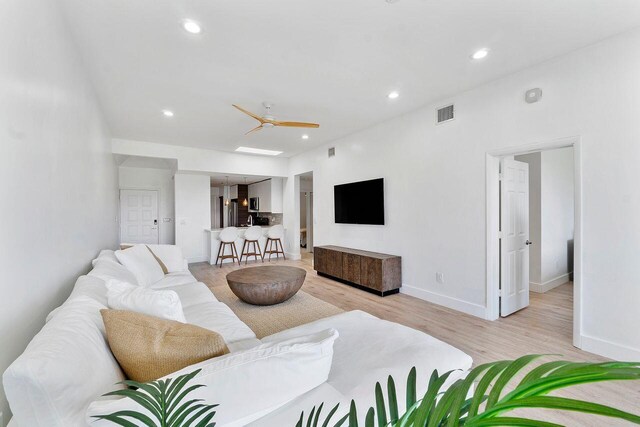 living room with ceiling fan and light hardwood / wood-style floors