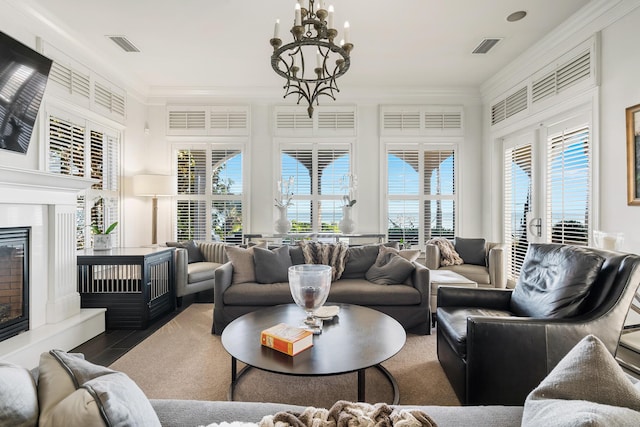 living room with a notable chandelier, crown molding, and wood-type flooring