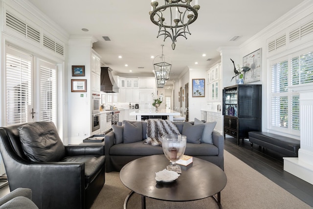 living room featuring ornamental molding, dark hardwood / wood-style flooring, and a notable chandelier