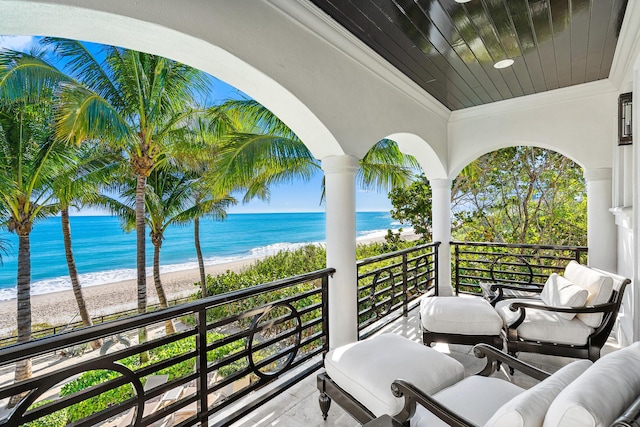 balcony featuring a beach view and a water view