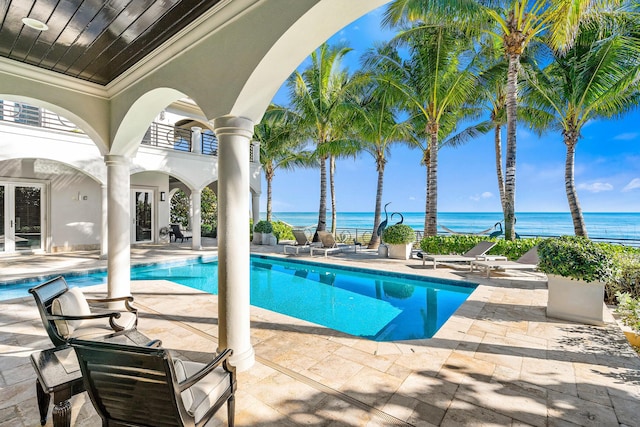 view of pool with a patio and a water view