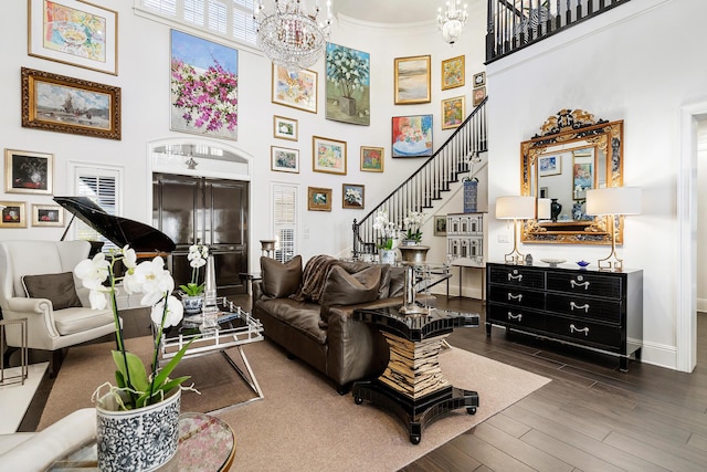 living room featuring crown molding, a towering ceiling, a chandelier, and dark hardwood / wood-style flooring