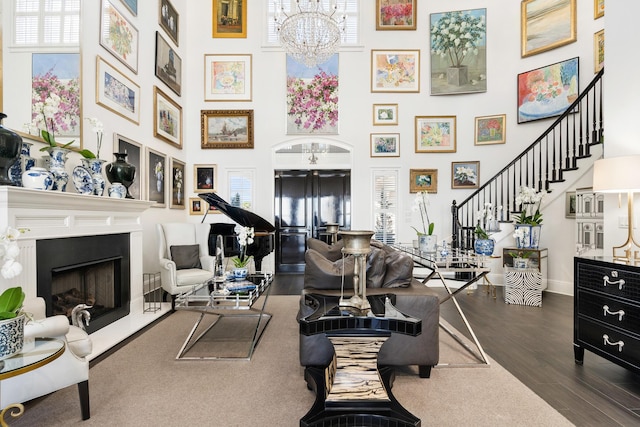 living room with a towering ceiling, an inviting chandelier, and dark hardwood / wood-style flooring