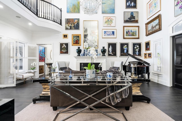 interior space with crown molding, hardwood / wood-style floors, a towering ceiling, and a chandelier