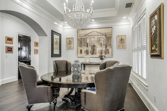 dining space featuring ornamental molding, dark wood-type flooring, and a tray ceiling