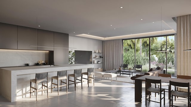 kitchen featuring gray cabinets, tasteful backsplash, a tray ceiling, expansive windows, and a kitchen bar