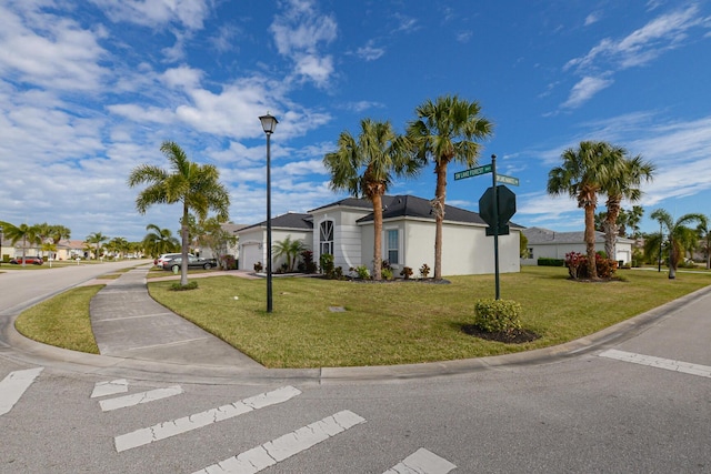 ranch-style home with a garage and a front lawn