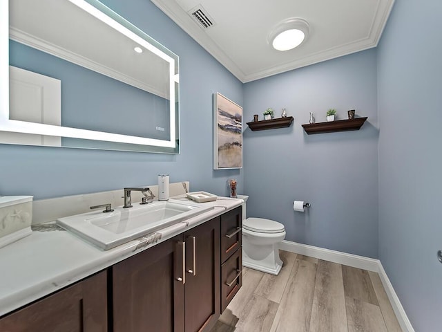 bathroom featuring ornamental molding, vanity, toilet, and hardwood / wood-style floors