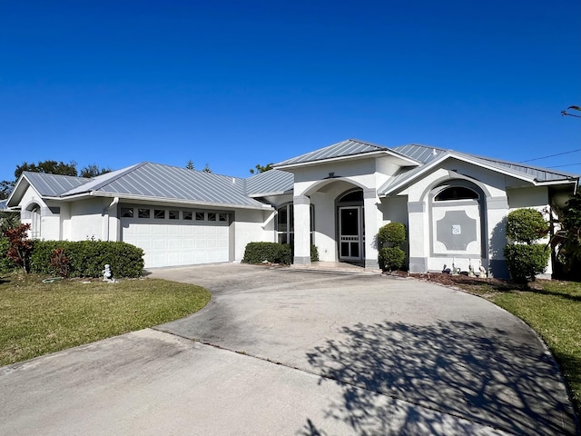 view of front of property with stucco siding, driveway, a standing seam roof, and metal roof
