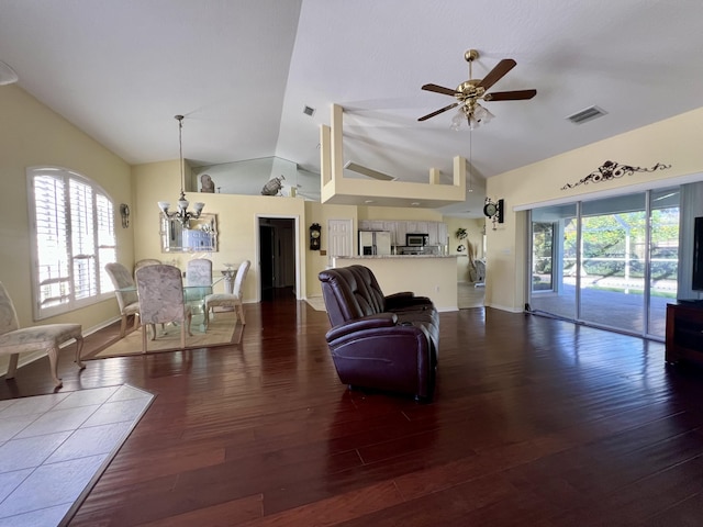 living room featuring dark hardwood / wood-style floors, ceiling fan with notable chandelier, and high vaulted ceiling