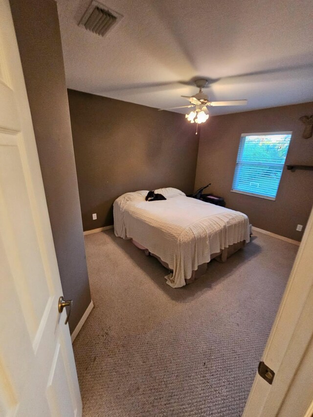 carpeted bedroom with a textured ceiling and ceiling fan