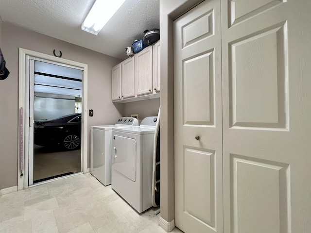 laundry room with cabinets, a textured ceiling, and washing machine and clothes dryer