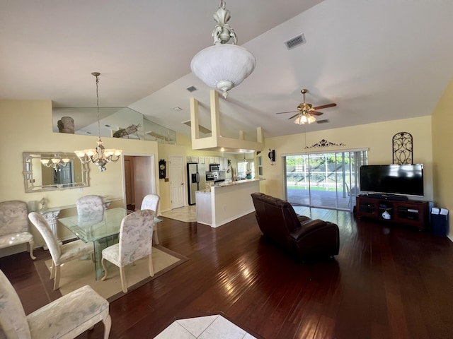 dining room featuring dark hardwood / wood-style flooring, ceiling fan with notable chandelier, and vaulted ceiling