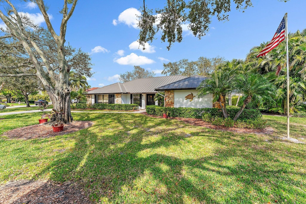single story home featuring a front lawn and metal roof