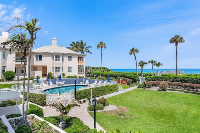 view of pool featuring a water view, a yard, and a patio area