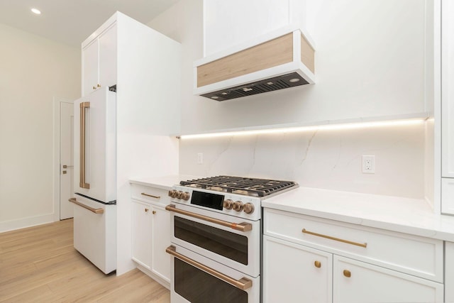 kitchen with custom exhaust hood, light wood-type flooring, recessed lighting, white appliances, and white cabinetry