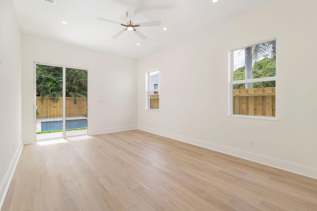 unfurnished room featuring light wood-style floors, a healthy amount of sunlight, and baseboards