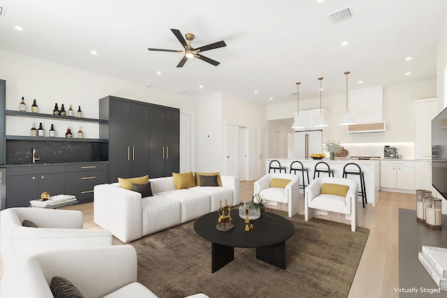 living area with visible vents, a ceiling fan, light wood finished floors, recessed lighting, and bar
