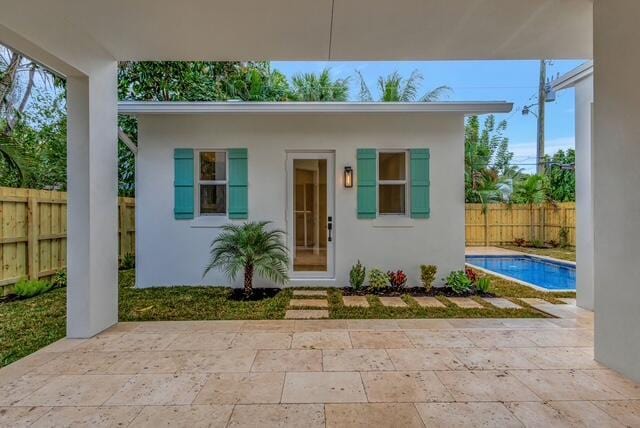 exterior space with a fenced in pool, a patio, stucco siding, and fence