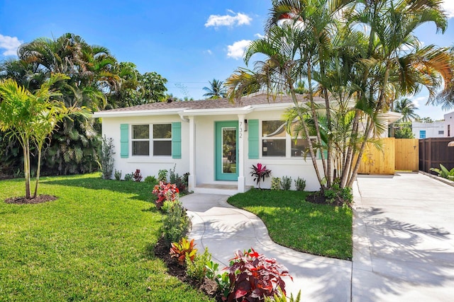 single story home featuring stucco siding, fence, and a front yard