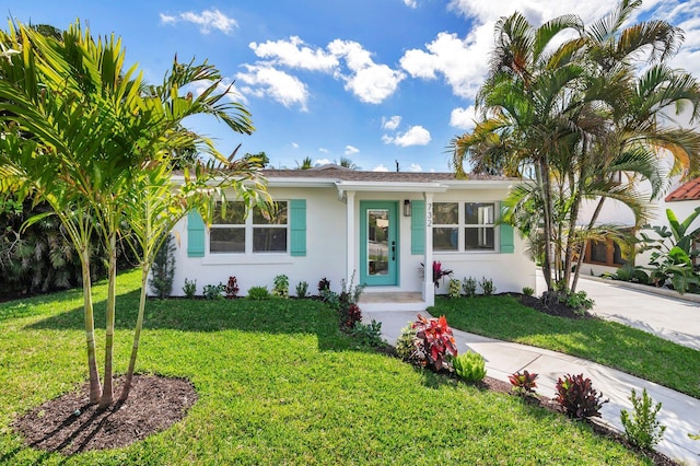view of front of property featuring concrete driveway, a front yard, and stucco siding