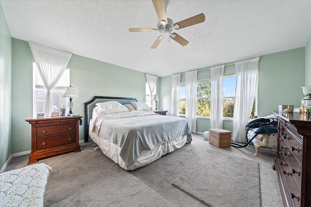 bedroom with light colored carpet, a textured ceiling, and ceiling fan