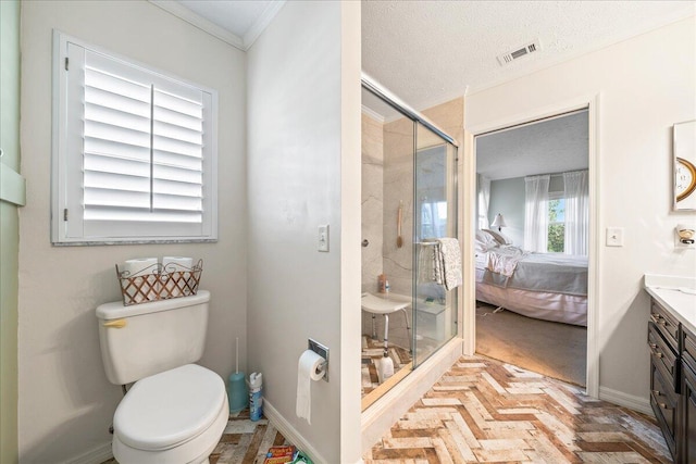 bathroom with vanity, ornamental molding, toilet, a shower with door, and a textured ceiling