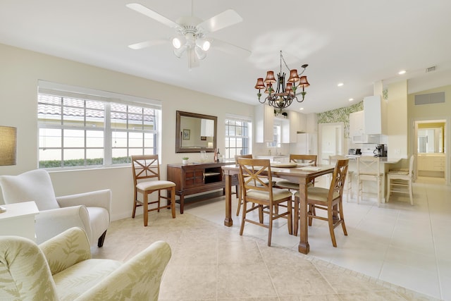 dining area with lofted ceiling, ceiling fan with notable chandelier, and light tile patterned floors