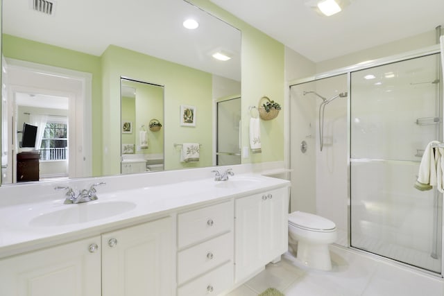 bathroom with tile patterned flooring, vanity, toilet, and a shower with shower door