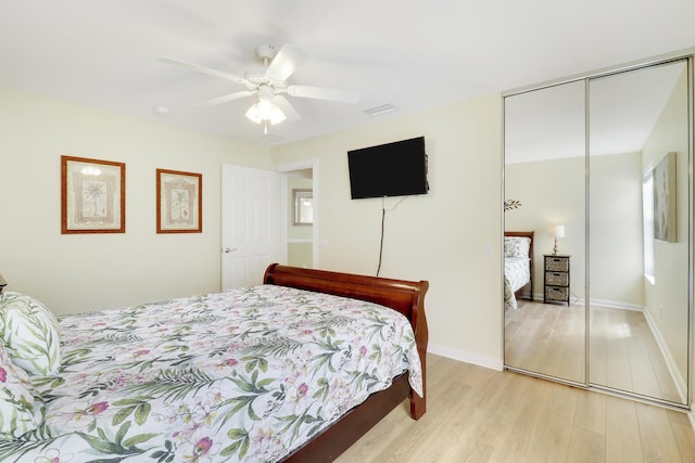 bedroom featuring ceiling fan, light hardwood / wood-style floors, and a closet