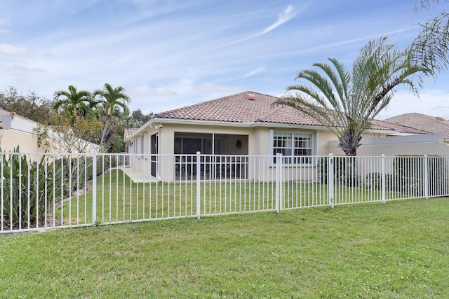 rear view of property featuring a yard and a sunroom