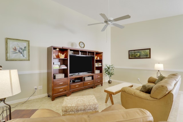 tiled living room with ceiling fan and a high ceiling