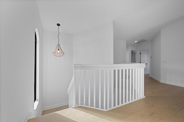 corridor with hardwood / wood-style flooring