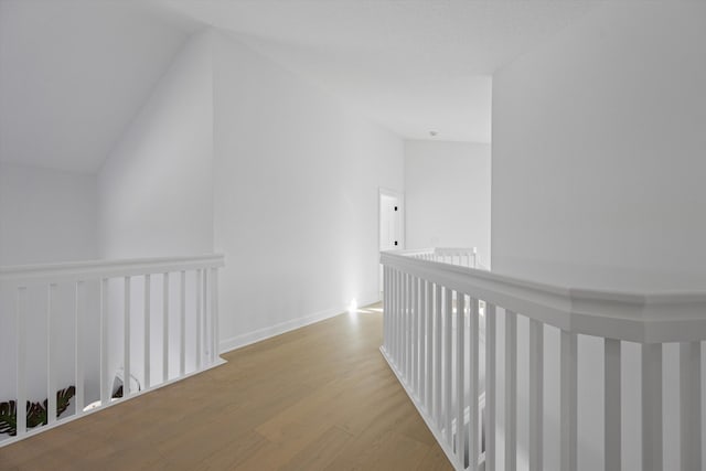 hall featuring lofted ceiling and light wood-type flooring