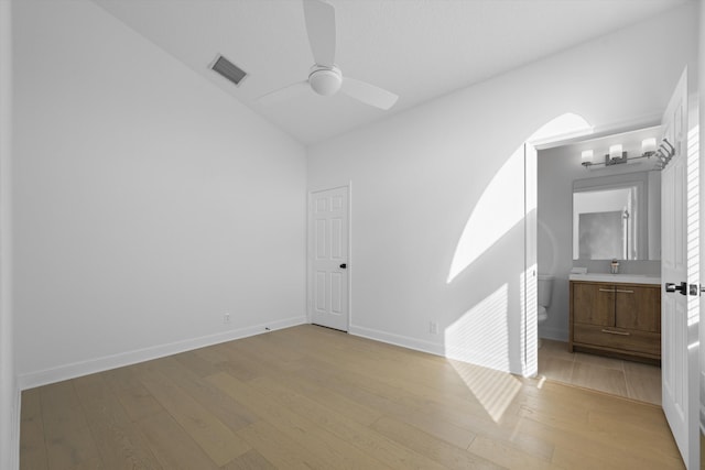 empty room featuring sink, ceiling fan with notable chandelier, and light hardwood / wood-style floors