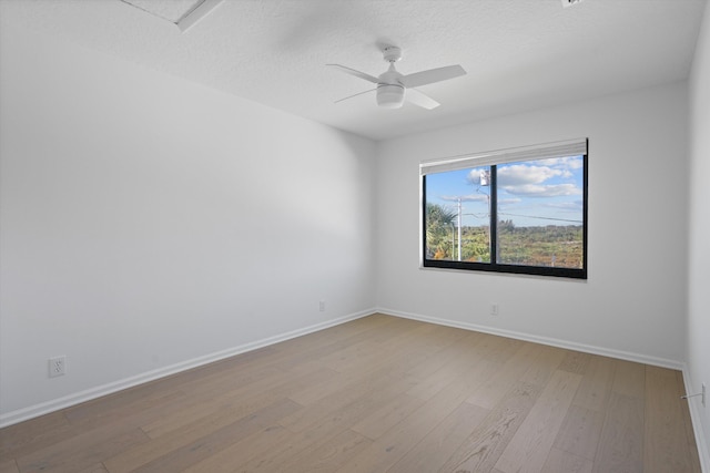 spare room with a textured ceiling, light hardwood / wood-style flooring, and ceiling fan