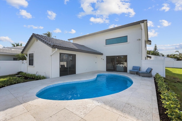 back of property featuring a fenced in pool and a patio area